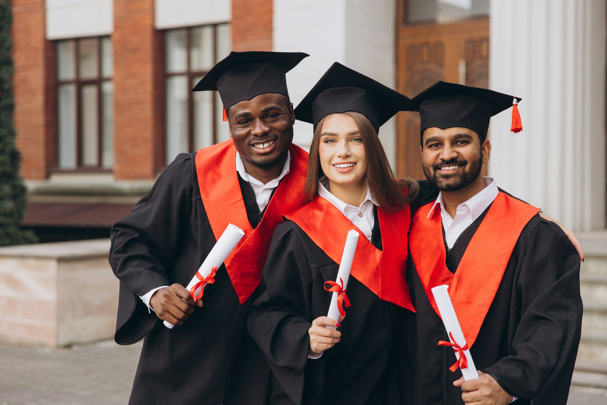 Group of Happy Graduates Celebrating with Diplomas in Hand at University Campus